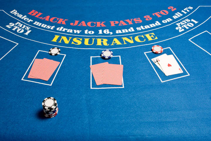 A person looking skeptically at a laptop displaying an online blackjack game.