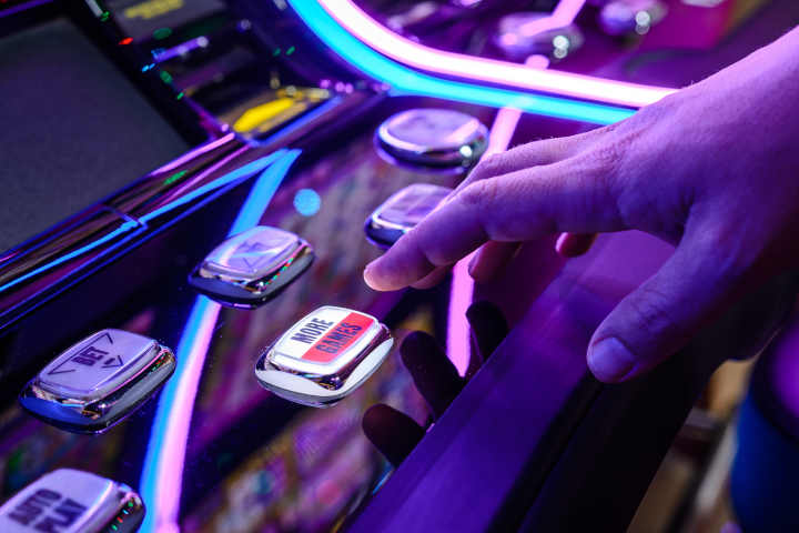 A row of brightly lit Australian pokies in a venue.