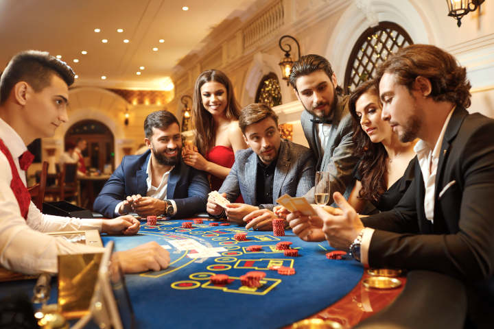A player waving their hand over their cards to signal 'stand' in blackjack.
