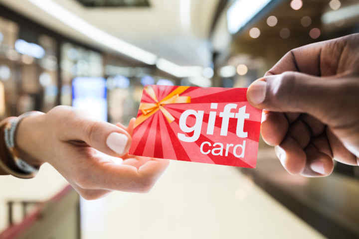 A hand holding a prepaid gift card