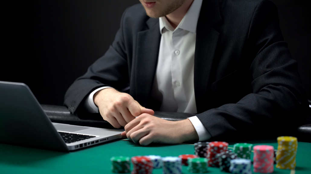 A person playing online poker on a laptop.