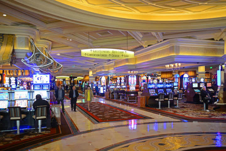 An empty, luxurious casino floor with slot machines and tables.