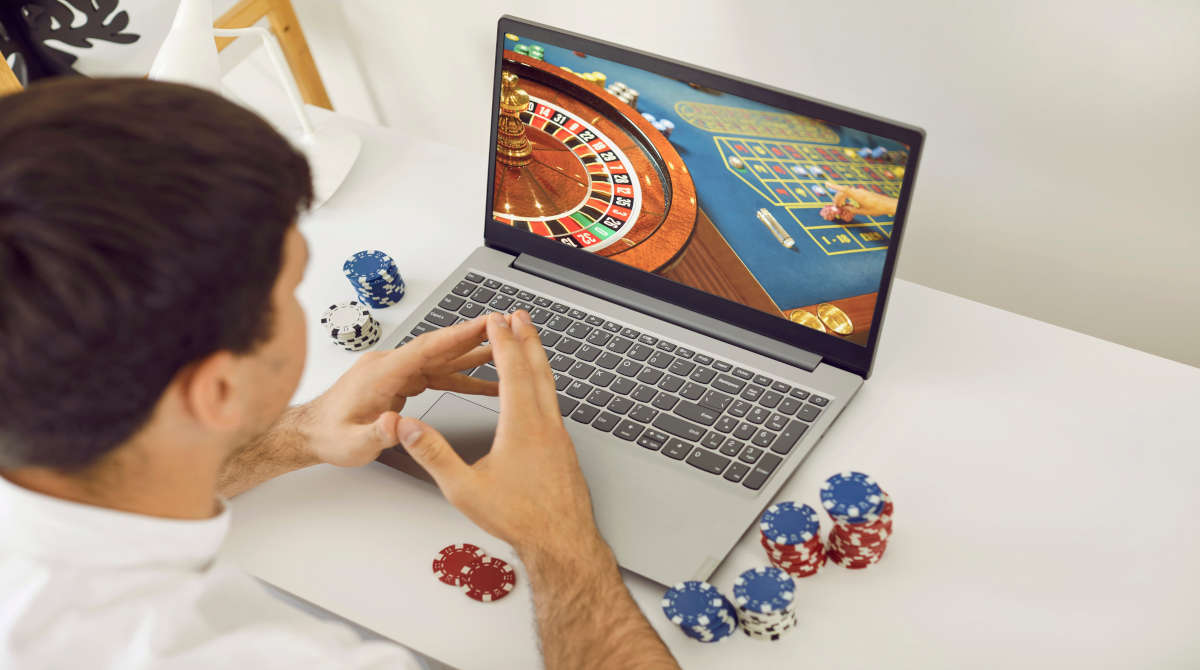 A live dealer spinning the roulette wheel during an online casino game.