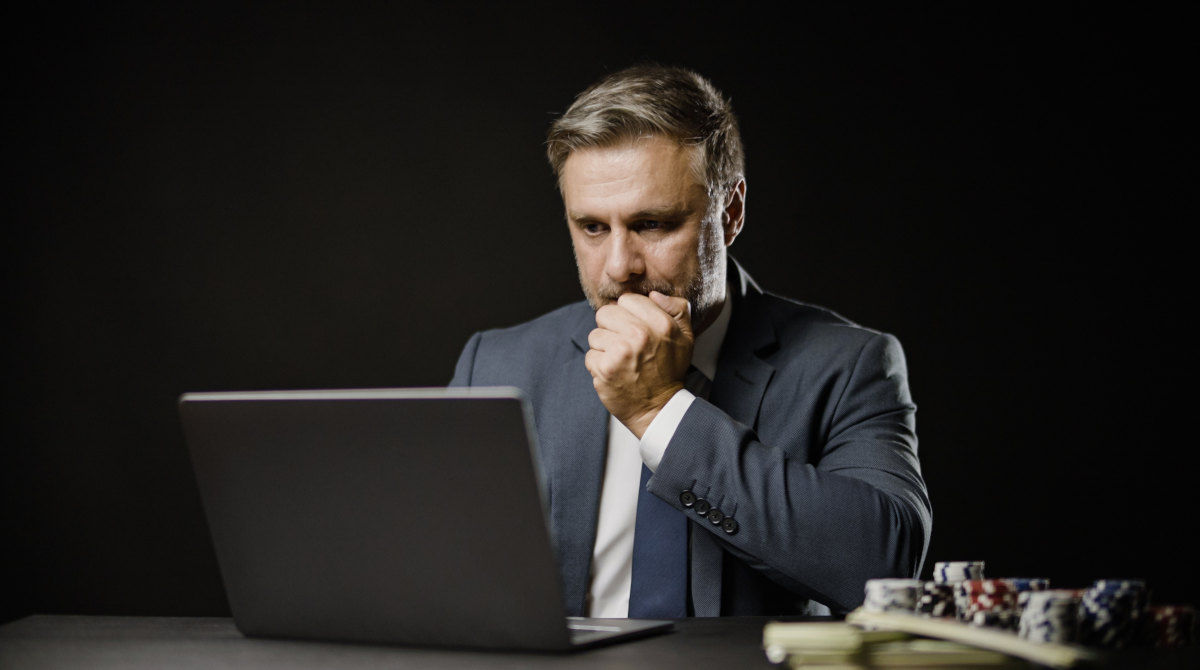 A person holding cash with a thoughtful expression.