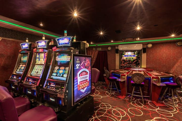 A brightly lit casino floor filled with various slot machines.