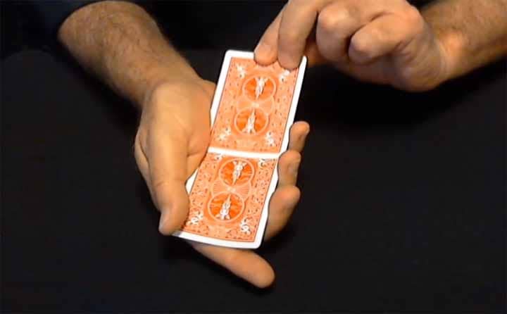 Close-up of hands performing a card trick.