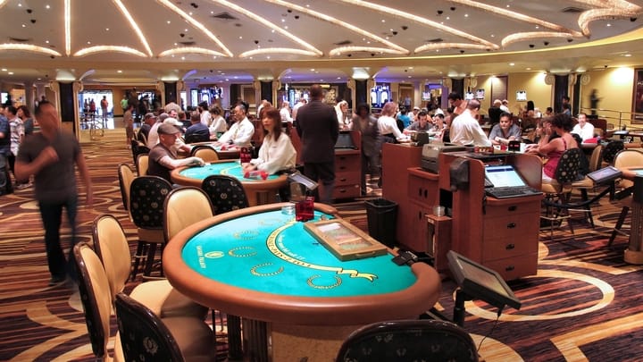 A dealer's hands showing cards at a blackjack table.