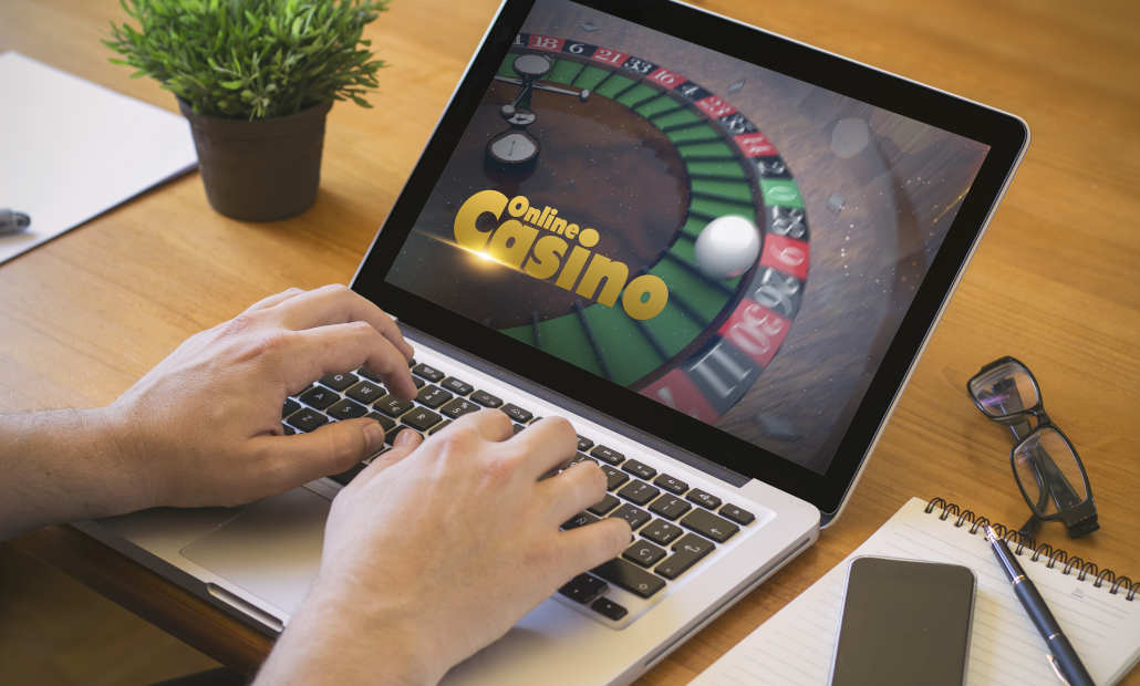 A graphic showing a stop sign over a laptop, symbolizing avoiding illegal online casinos.