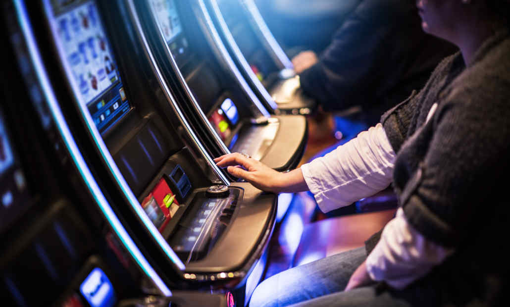 A person playing a colorful slot machine