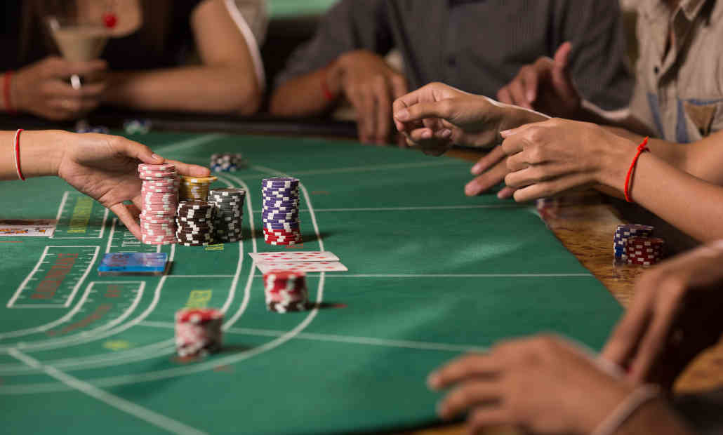 A baccarat table layout with cards and betting spots for Player, Banker, and Tie.
