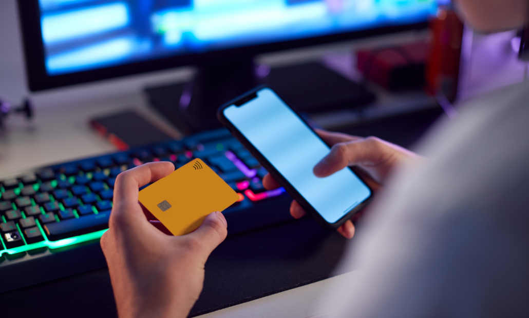 A person holding playing cards over a casino table.