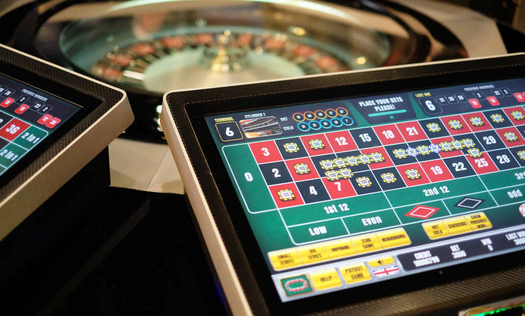 A multiplayer electronic roulette terminal with a central wheel.