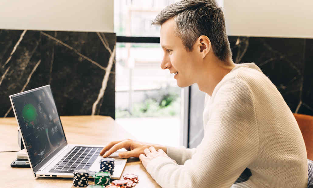 A person using a laptop to find the best casino bonuses online.