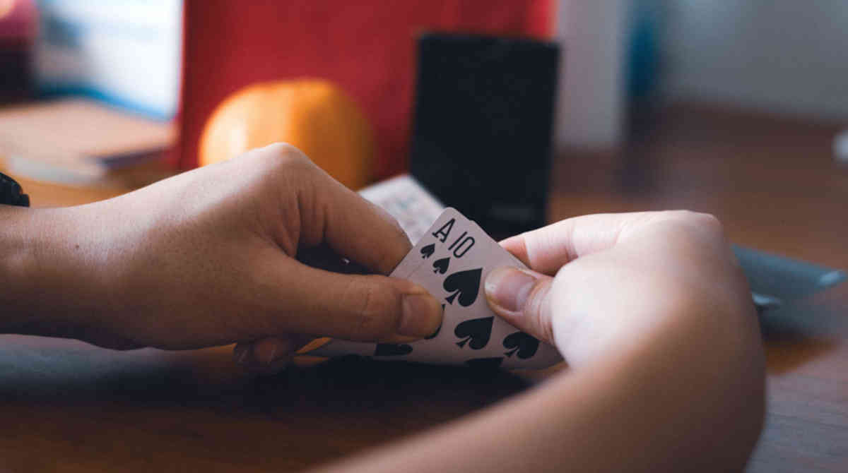 A person dealing blackjack cards on a green felt table.