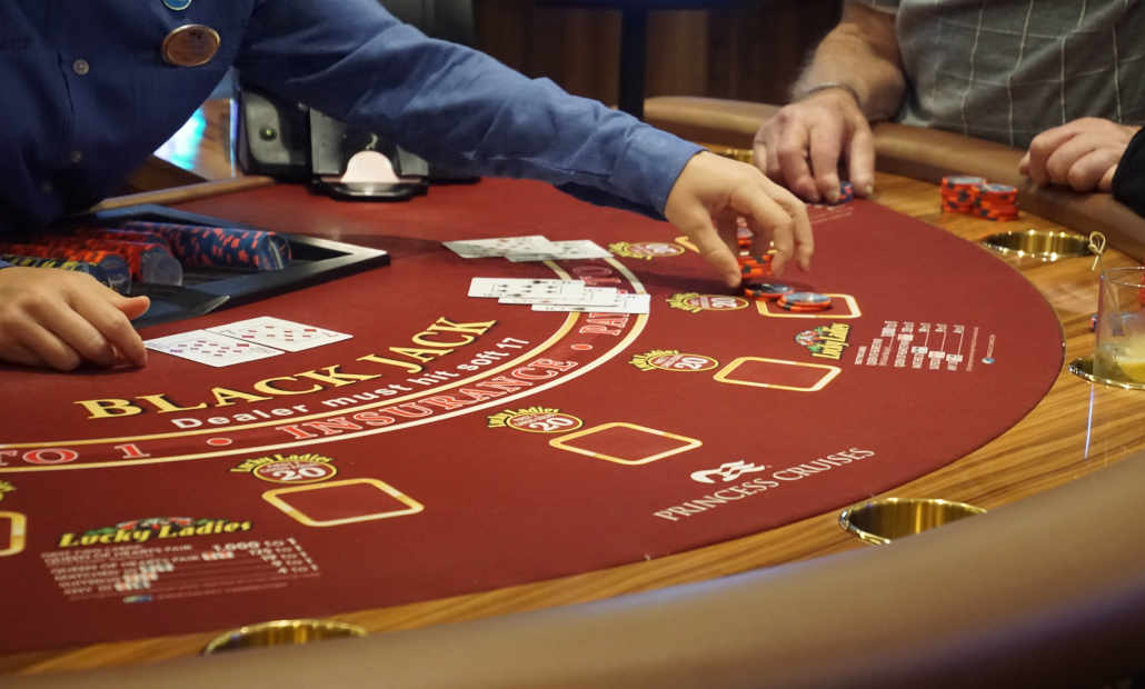 Player holding playing cards at a casino table.