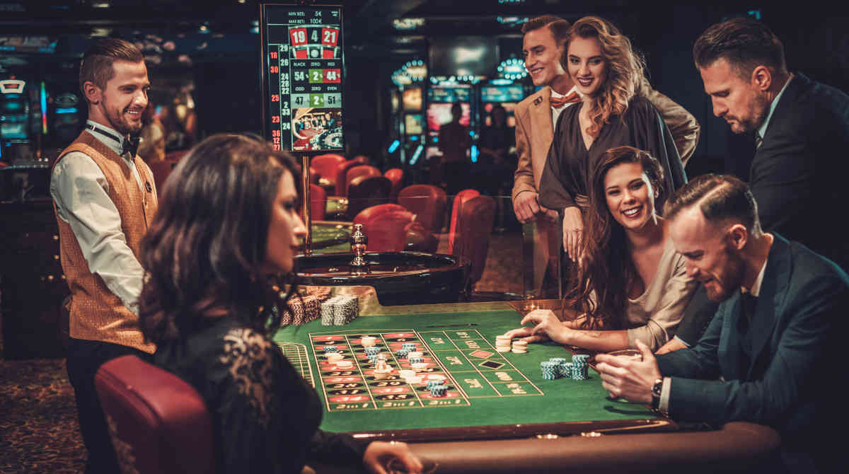 Players gathered around a roulette table in a traditional casino.