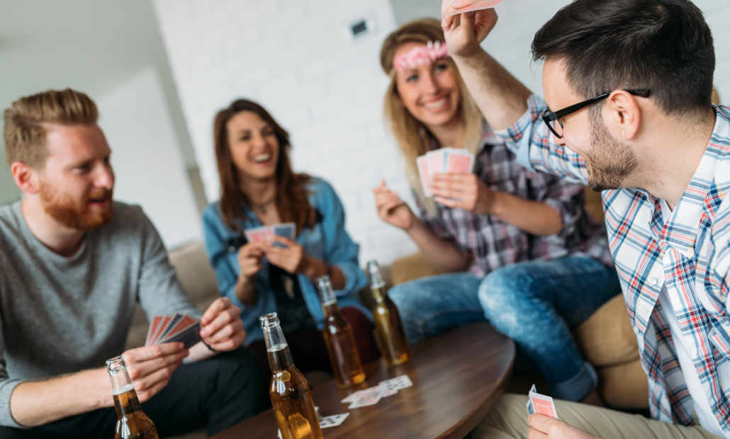 Friends laughing and playing cards together.