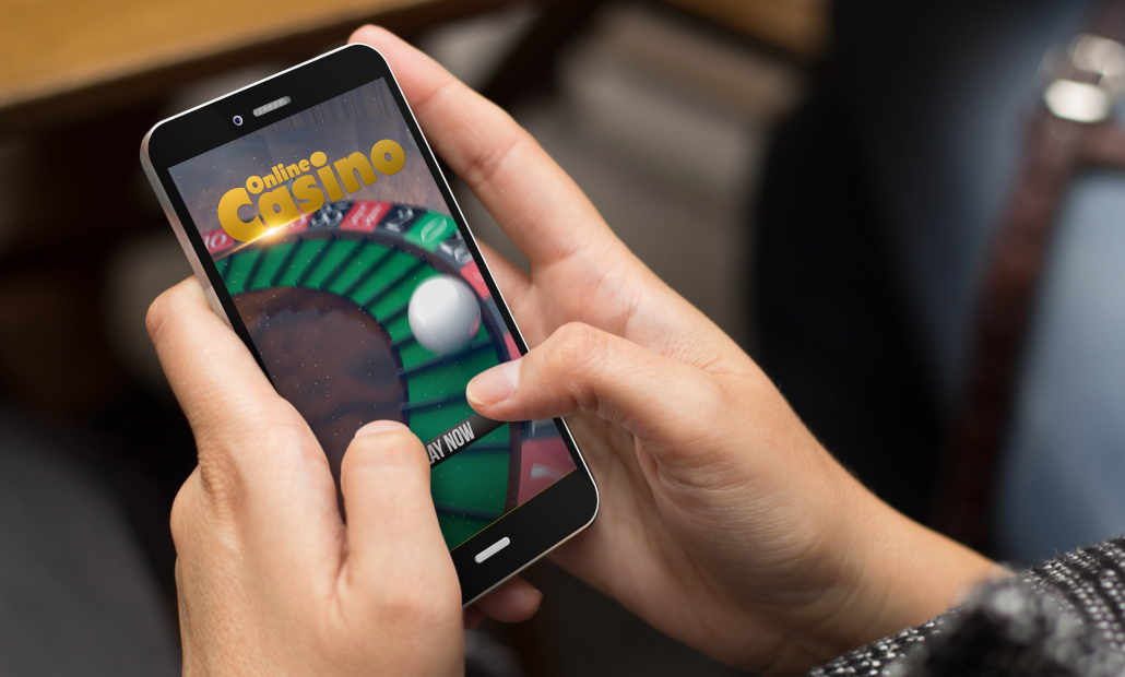 A person holding a smartphone displaying a mobile casino interface.
