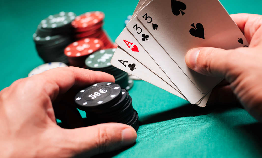 Four aces being held by a player in an Omaha poker game.