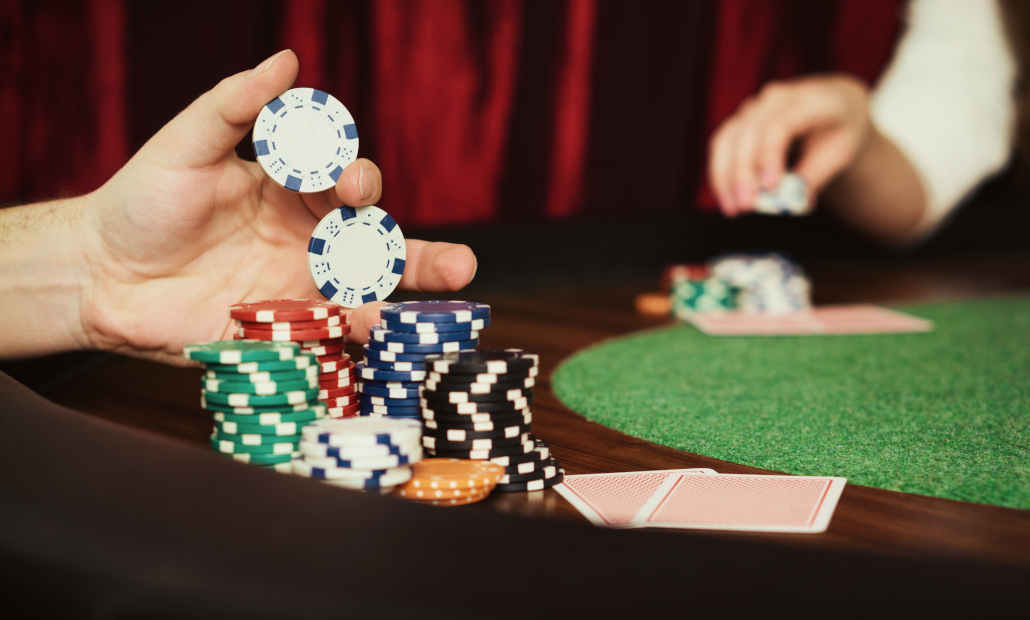 A focused poker player at a table with chips and cards.