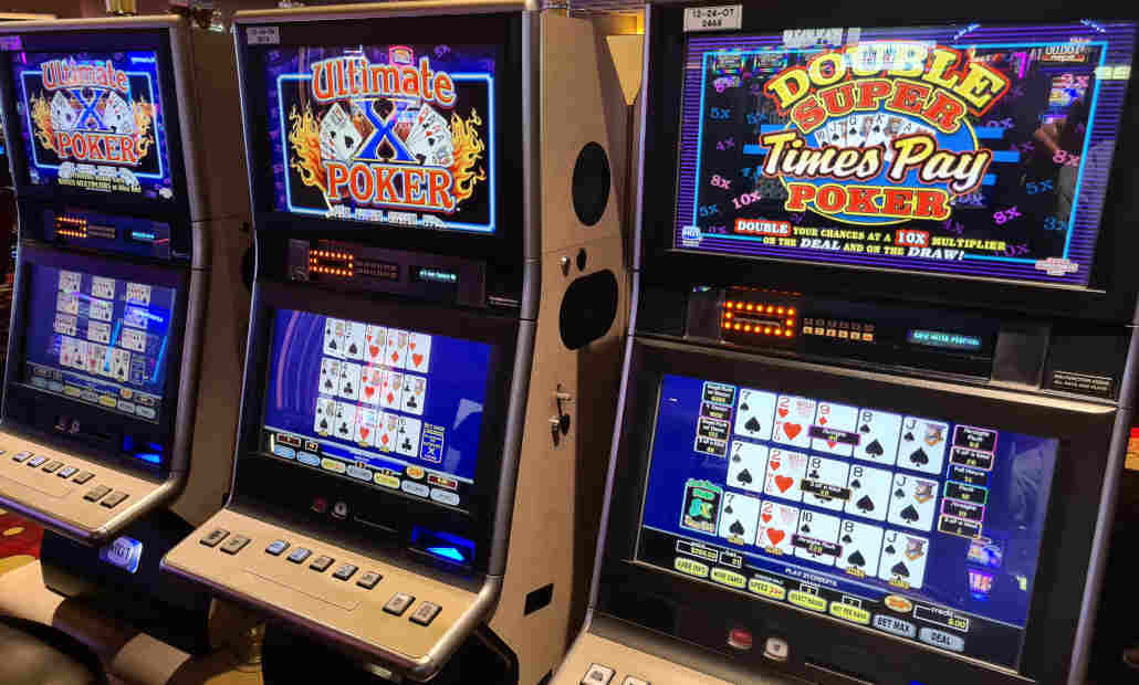 A person playing a video poker machine in a casino.