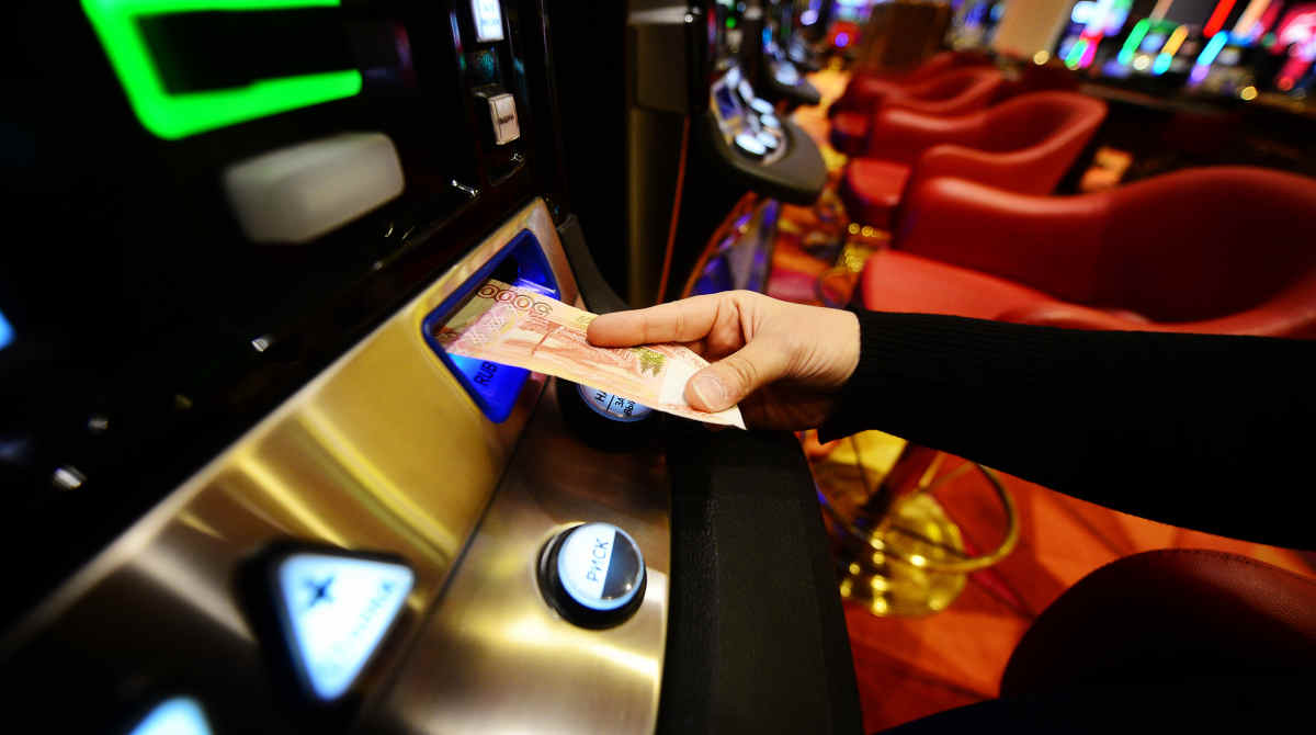 A person playing a video poker machine in a casino setting.