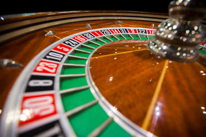 A detailed shot of a spinning French Roulette wheel with the ball in motion.