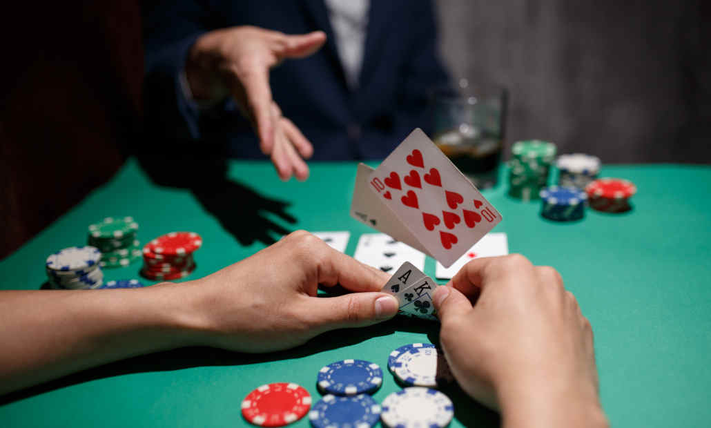 Poker chips and cards with a player considering their move.