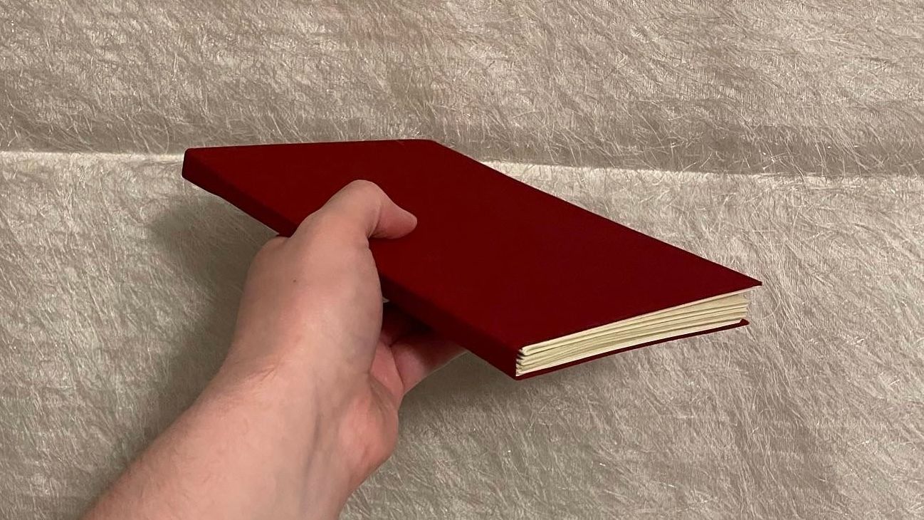 A red handmade notebook with parchment paper.