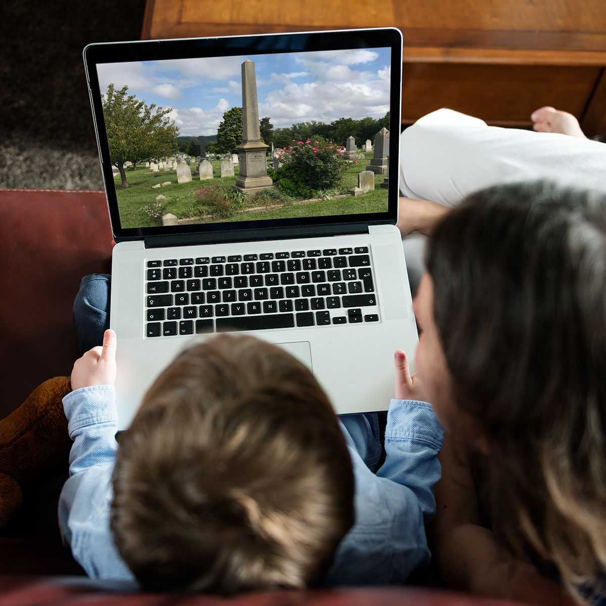 two people sitting on a couch with a laptop