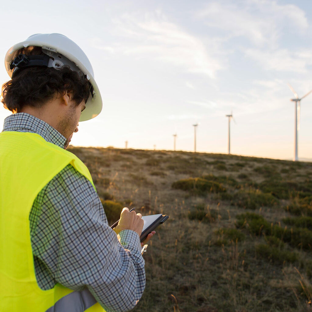 wind farms fields field worker completing land access work form on phone