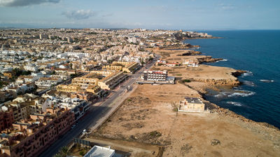 Mesmerizing cityscape meets pristine sea waters in a captivating aerial view, showcasing vibrant architecture and bustling energy below. Torrevieja, Spain