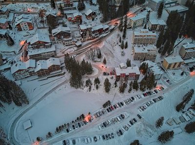 Snowy alpine village of Arosa in twilight from above