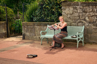 Young woman playing flute on a street of Edinburgh