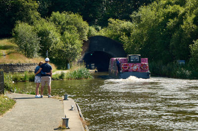 A boat entering the tunnel near the Falkirk Wheel. A romantic couple on the shore