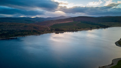 aerial picture of a water reservoir and remote mountains at twilight