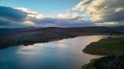 Aerial view of a water reservoir at night with a colourful sky.