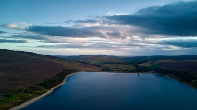a colourful sky and an aerial picture of a water reservoir at dusk.