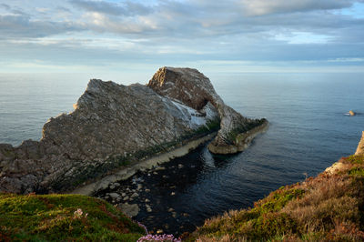 Bow Fiddle Rock - a natural sea arch in the evening under the vibrant sky