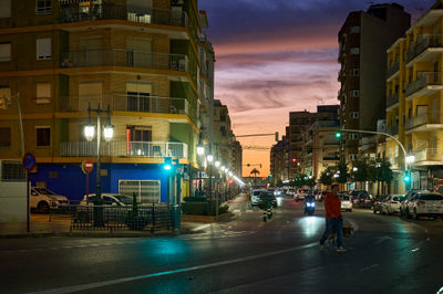 Cullera, Spain 05.21.2023 Vibrant city street at dusk captures the energy and charm of urban life. Cars, people, and a happy dog bring this painting to life