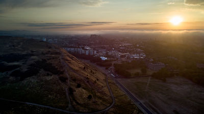 Aerial view of Edinburgh at sunset. Edinburgh Castle can be seen at distance in the clouds