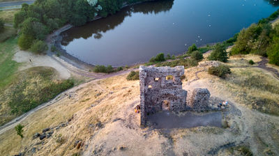 Ruin of St Anthony Chapel and Saint Margaret Loch in summer evening - from drone