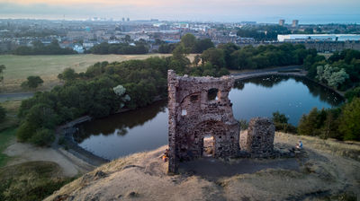 Ruin of St Anthony Chapel and Saint Margaret Loch in summer evening - drone photo