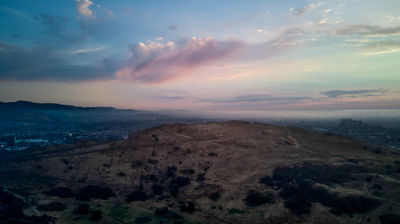 Drone photo of Edinburgh - flying over Arthur's Seat. Edinburgh Castle can be seen at distance