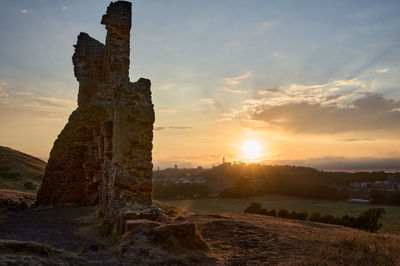 Sunset over Edinburgh with ruins St Anthony Chapel on a foreground