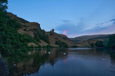 Evening in Holyrood Park. Saint Margaret's Loch. Ruin of St Anthony Chapel agains colourful sky