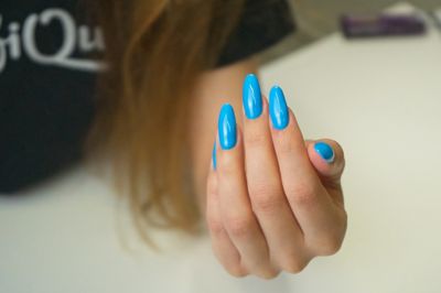 A hand with a blue manicure