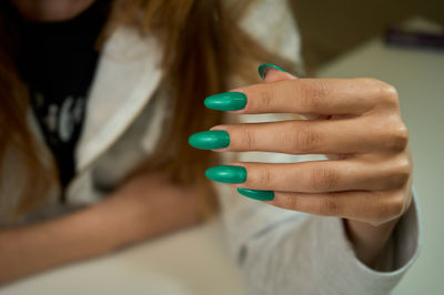 A hand with a green manicure