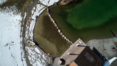 A small lake in Alps with a boat - from above