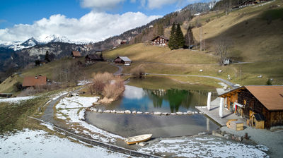 An alpine village with a small lake from the air